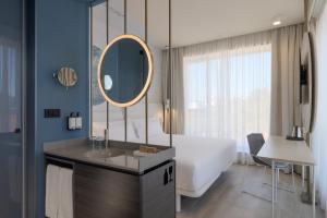 a bathroom with a tub and a sink and a mirror at Occidental Ljubljana in Ljubljana