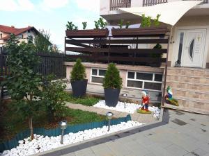 a garden in front of a house with trees at Apartment Nina-bazen-klima-parking in Otočac +77 photos