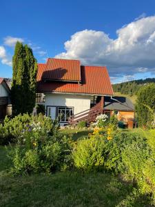 una casa con un tetto arancione e alcuni cespugli di Cabana La Plai - idyllic natural setting a Vatra Dornei Altre 94 foto