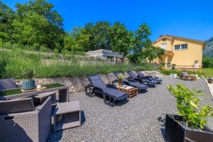 Un patio con tumbonas y una mesa. en Emaris, en Tribalj