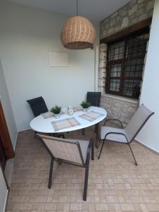a white table and chairs in a room at Casa Leone, whole house with private pool! in Atsipopoulo +16 photos
