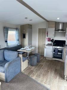 a living room and kitchen with a table and a couch at 22 Stowford Gardens Combe Martin in Combe Martin