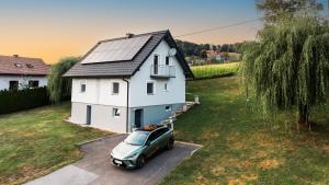 een auto geparkeerd voor een wit huis bij Ferienhaus Treissmann an der Weinstraße in Leutschach
