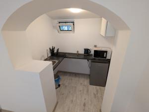 a small kitchen with a sink and a microwave at Serene Studio in Bucharest