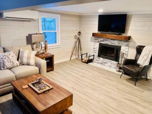 a living room with a couch and a fireplace at Lakefront Cottage on Brewer Lake in Holden