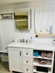 ein weißes Badezimmer mit Waschbecken und Spiegel in der Unterkunft Lakefront Cottage on Brewer Lake in Holden + 49 Fotos