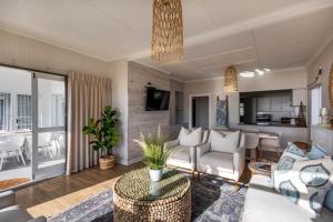 una sala de estar con un sofá y una mesa en 19 Hill Street, en Plettenberg Bay