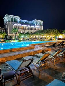 una fila di sedie e una piscina di notte di Tskaltubo Hotel Prometheus a Tskhaltubo