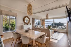 Un comedor con una mesa y una sala de estar. en 19 Hill Street, en Plettenberg Bay