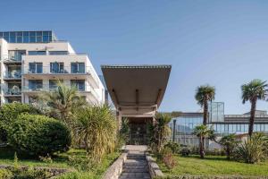 a building with palm trees in front of it at Eurostars Queen of Montenegro in Budva