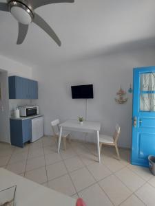 a kitchen with a white table and a blue door at Milithos Apartments 1 in Adamantas
