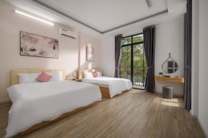 a hotel room with two beds and a window at Cam On Luxury Pool Villa by Beach - Free Airport Pickup in Da Nang