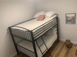 a bunk bed with white sheets and pillows on it at Beachview getaway at the New Carlyle 304 on the Main strip in Grand Bend in Grand Bend