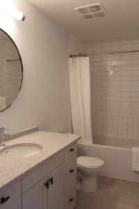 a bathroom with a sink and a toilet and a mirror at Beachview getaway at the New Carlyle 200 on the Main strip in Grand Bend in Grand Bend +21 photos