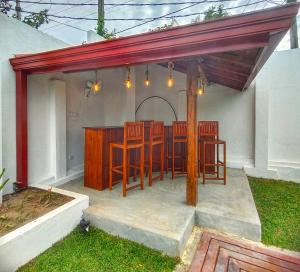 a patio with a table and chairs under awning at The White House Resort in Wellawaya