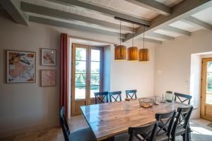 a dining room with a wooden table and chairs at Les Blancs - Maison de maître entourée de vignes in Lisle-sur-Tarn