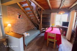 a room with a table and a bed in a room at La Laguna - Cabañas de Troncos in Merlo