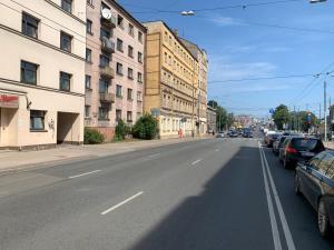 an empty city street with parked cars and buildings at Mini cinema & movie studio with PS5 in Riga