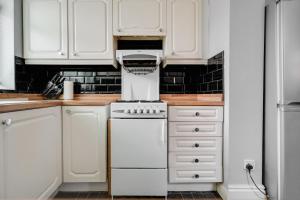 cocina con armarios blancos y estufa blanca en Manchester Business and Leisure Home with Free Parking, en Mánchester