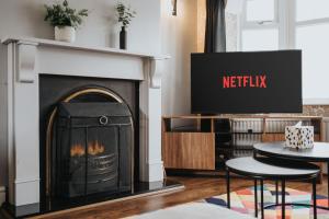 マンチェスターにあるManchester Business and Leisure Home with Free Parkingの暖炉とテレビのあるリビングルーム