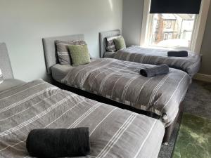 ein Schlafzimmer mit zwei Betten und einer Couch darin in der Unterkunft The Clifton Guest House in Liverpool + 7 Fotos