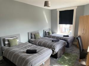 ein Zimmer mit zwei Betten und einem Flachbildfernseher in der Unterkunft The Clifton Guest House in Liverpool