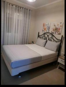 a bedroom with a large bed with white sheets at Ενοικιαζόμενο Διαμέρισμα in Lygia