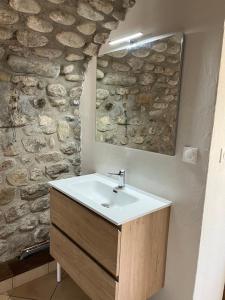 łazienka z umywalką i kamienną ścianą w obiekcie GITE DE LA CAPPELLA - CHAMBRE D'HÔTES A VOLTA w mieście Aubenas +11 zdjęć