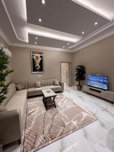 a living room with a couch and a tv at شقة أنيقة غرفة نوم وصالة الفيحاء in Riyadh +23 photos
