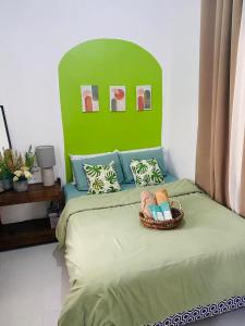 a bedroom with a bed with a basket of towels at Karlana Breeze 101 in Cabug
