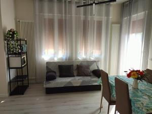 a living room with a couch in front of a window at Domus Anna in Montegrotto Terme