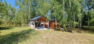 a small cabin in the middle of a field at Domek w lesie in Łopuszno