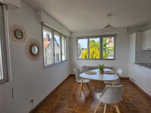 a kitchen and dining room with a table and chairs at Le1bis - T2 50 M2 tout équipé - Place de parking Privée in Sainte-Savine +7 photos
