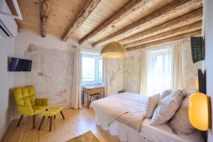 a bedroom with a large bed and a yellow chair at Villa Porta no in Bale