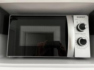 a microwave oven with a persons hand in it at Fewo Klein Venedig in Bamberg