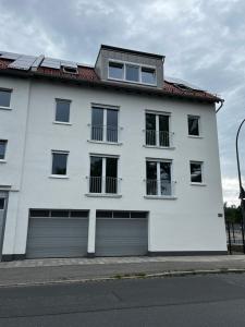 a white building with two garage doors on a street at Fewo Klein Venedig in Bamberg