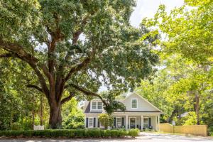 a house with a large tree in front of it at Downtown Os Artistic Stay W Fire Pit, Game Room! in Ocean Springs