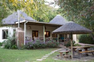 a house with a picnic table and an umbrella at Frog Mountain Getaway in Swellendam
