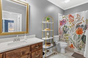a bathroom with a sink and a toilet and a mirror at Downtown Os Artistic Stay W Fire Pit, Game Room! in Ocean Springs +46 photos