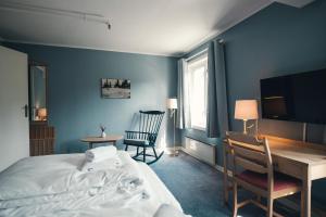 a bedroom with a bed and a desk and a tv at Gålå Høgfjellshotell in Gålå