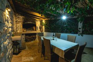 a dining room with a table and a fireplace at Villa matulic in Postira