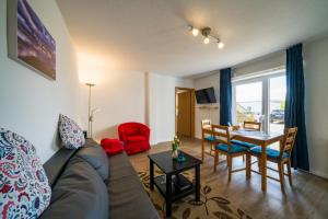 a living room with a couch and a table at Ferienwohnug Strandflieder in Borkum