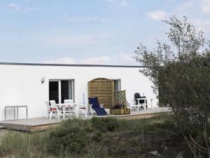 Casa blanca con sillas y una mesa en una terraza en Ferienwohnung Möwe, en Borkum 7 fotos más