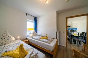 1 dormitorio con 2 camas y comedor en Ferienwohnung Möwe, en Borkum