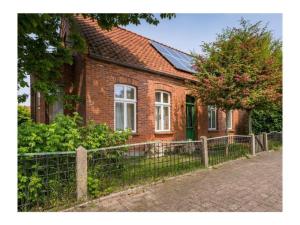 a brick house with a fence in front of it at Ferienhaus Sommerlust in Borkum