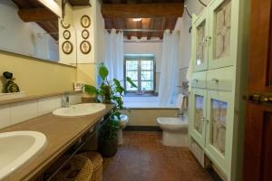 a bathroom with two sinks and a toilet and a window at Vivaia Trendy Rural in Poggibonsi