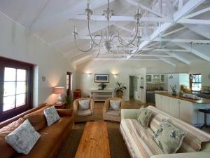 a living room with a couch and a chandelier at Frog Mountain Getaway in Swellendam