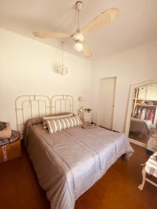 a bedroom with a bed with a ceiling fan at Casa centro Urquiza in Gualeguaychú