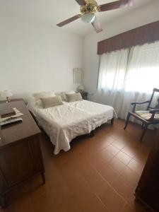 a bedroom with a bed and a ceiling fan at Casa centro Urquiza in Gualeguaychú