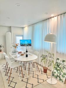 una sala da pranzo bianca con tavolo e sedie bianchi di Almond House, Busan Gwang-an a Busan